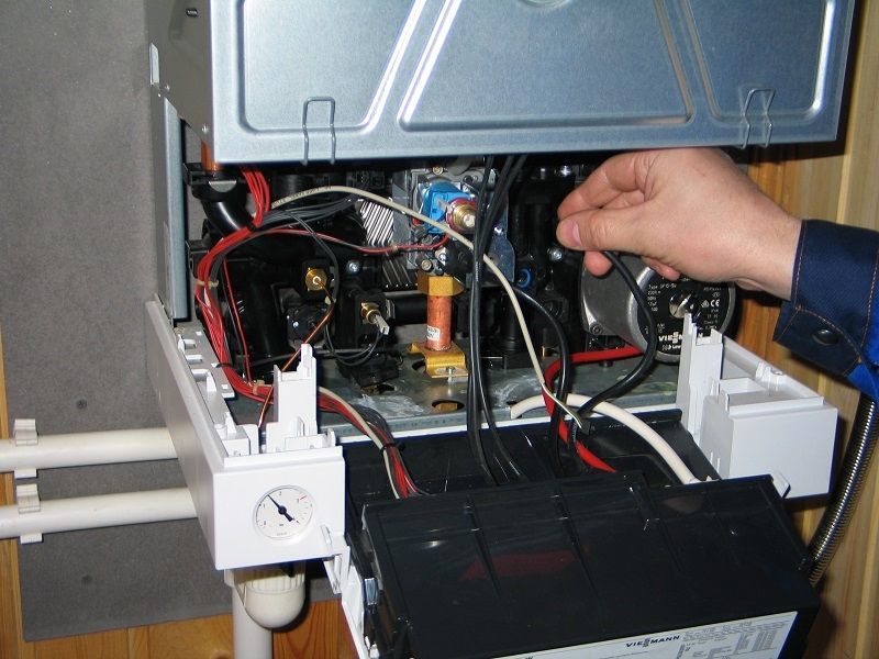Специалист ремонтирует электрический котел